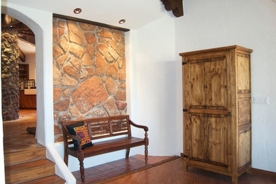 Idéer för att renovera en mellanstor medelhavsstil entré, med vita väggar, mellanmörkt trägolv och brunt golv
