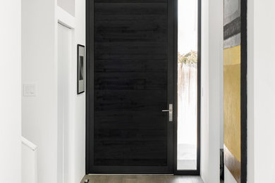 デンバーにあるコンテンポラリースタイルのおしゃれな玄関 (白い壁、濃色無垢フローリング、黒いドア、グレーの床) の写真