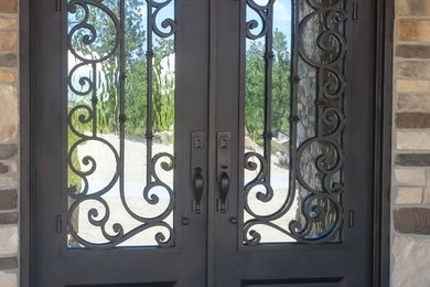 Foto de puerta principal clásica de tamaño medio con paredes beige, suelo de cemento, puerta doble, puerta metalizada y suelo gris