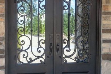 This is an example of a medium sized traditional front door in Denver with beige walls, concrete flooring, a double front door, a metal front door and grey floors.