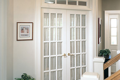 Стильный дизайн: узкая прихожая среднего размера в классическом стиле с белыми стенами, ковровым покрытием, двустворчатой входной дверью и белой входной дверью - последний тренд