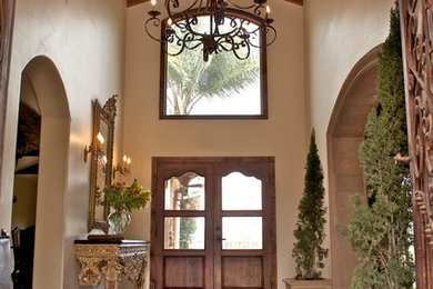 Large tuscan terra-cotta tile and orange floor entryway photo in San Diego