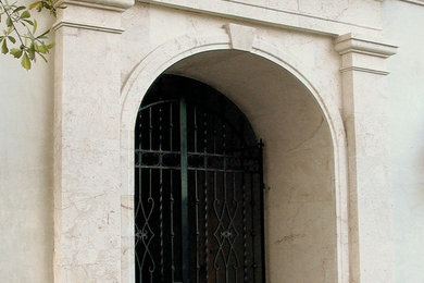 ニューオリンズにある広い地中海スタイルのおしゃれな玄関ドア (黒いドア) の写真