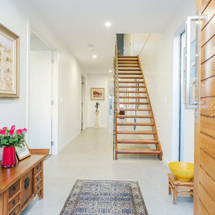 Photo of an asian foyer in Adelaide with white walls, a single front door, a medium wood front door and grey floor.