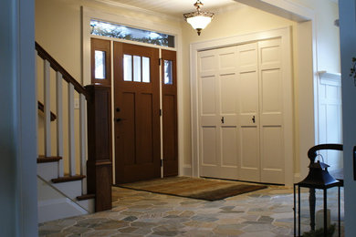 Ispirazione per un ingresso chic di medie dimensioni con pareti beige, pavimento in ardesia, una porta singola e una porta in legno scuro