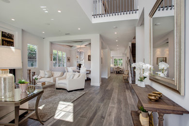 Entryway - large transitional medium tone wood floor and brown floor entryway idea in Los Angeles with gray walls
