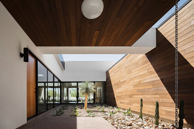 Ispirazione per un grande ingresso minimalista con pareti multicolore, pavimento in cemento, una porta singola, una porta in legno chiaro, pavimento grigio, soffitto in legno e pareti in legno