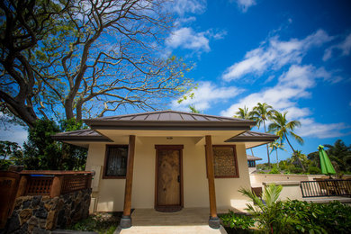 Inspiration for a large world-inspired entrance in Hawaii with white walls, limestone flooring, a medium wood front door and multi-coloured floors.
