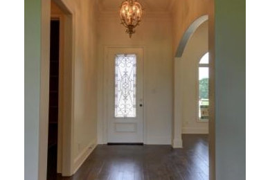 Foto de hall tradicional de tamaño medio con paredes blancas, suelo de madera oscura, puerta simple y puerta blanca