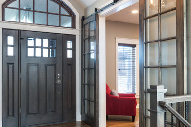 Transitional medium tone wood floor single front door photo in Chicago with gray walls and a dark wood front door