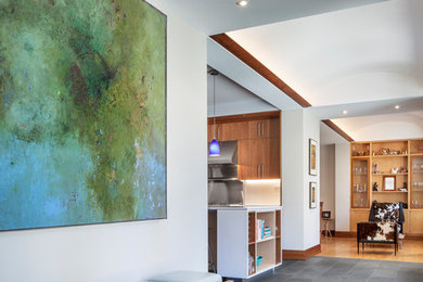 This is an example of a contemporary foyer in Toronto with white walls and grey floors.