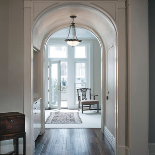 Immagine di un ingresso chic con pareti grigie, parquet scuro, una porta singola, una porta in vetro e pavimento marrone