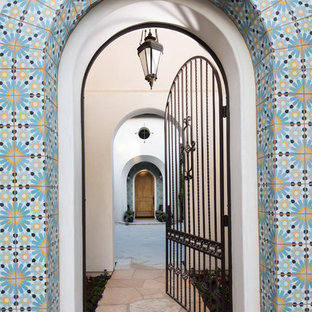 Imagen de entrada mediterránea con puerta simple y puerta de madera oscura