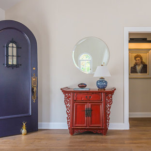 Inspiration för stora klassiska ingångspartier, med beige väggar, mellanmörkt trägolv, en enkeldörr, en lila dörr och brunt golv