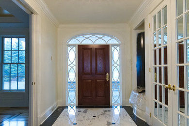 Entryway - marble floor entryway idea in Other with white walls and a dark wood front door