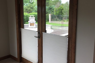 Imagen de puerta principal clásica pequeña con paredes beige, suelo de madera en tonos medios, puerta doble, puerta de vidrio y suelo marrón