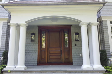 Modelo de puerta principal tradicional grande con paredes grises, suelo de piedra caliza, puerta simple y puerta de madera oscura