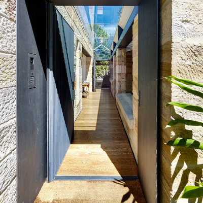 Trendy light wood floor and brown floor entryway photo in Sydney with a metal front door and brown walls