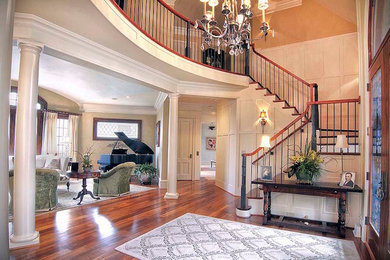 Inspiration for a large timeless dark wood floor and brown floor entryway remodel in Raleigh with beige walls and a glass front door
