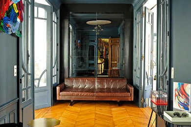 Foto di un grande corridoio boho chic con pareti grigie, parquet chiaro, una porta a due ante, una porta blu e pavimento beige