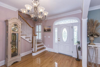 Mid-sized elegant light wood floor and brown floor entryway photo in Orlando with pink walls and a white front door