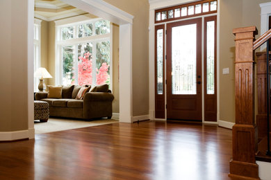 Imagen de hall clásico de tamaño medio con paredes marrones, suelo de madera oscura, puerta simple, puerta de vidrio y suelo marrón