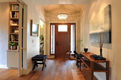 Imagen de distribuidor de estilo americano de tamaño medio con paredes beige, puerta simple, puerta de madera en tonos medios, suelo de madera en tonos medios y suelo marrón