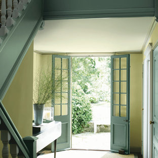 Inspiration för mellanstora shabby chic-inspirerade foajéer, med gula väggar, mörkt trägolv, en dubbeldörr, en blå dörr och brunt golv