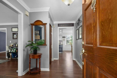 コロンバスにある中くらいなトラディショナルスタイルのおしゃれな玄関ホール (グレーの壁、濃色無垢フローリング、濃色木目調のドア、茶色い床) の写真