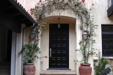 Medium sized mediterranean front door in Los Angeles with beige walls, ceramic flooring, a single front door and a black front door.