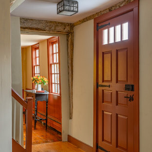 Idée de décoration pour une porte d'entrée champêtre de taille moyenne avec un mur blanc, un sol en bois brun, une porte simple et une porte rouge.