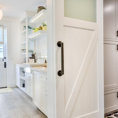 Example of a mid-sized country vinyl floor entryway design in Orange County with white walls and a white front door