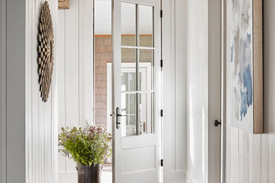 Inspiration for a transitional medium tone wood floor, brown floor, shiplap ceiling, vaulted ceiling and shiplap wall entryway remodel in Atlanta with white walls and a white front door