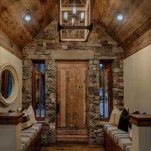 Idee per un ingresso rustico di medie dimensioni con pareti beige, pavimento in legno massello medio, una porta singola e una porta in legno scuro