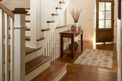 Example of a mid-sized classic medium tone wood floor entryway design in Minneapolis with white walls and a dark wood front door