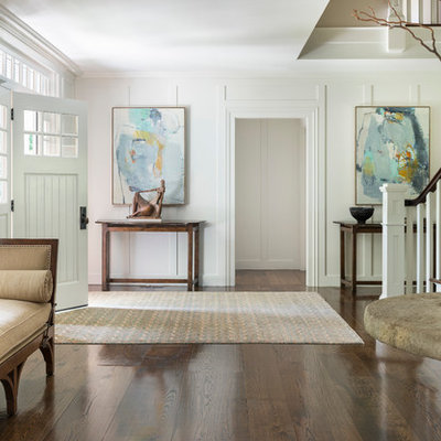 Example of a transitional dark wood floor entryway design in New York with white walls and a white front door