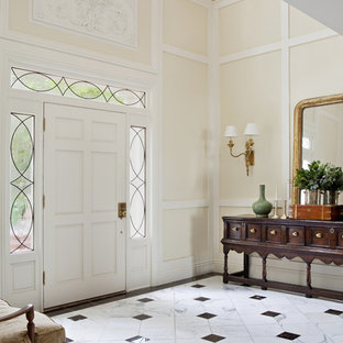 Ispirazione per un grande ingresso classico con pareti beige, una porta singola, una porta bianca e pavimento in marmo