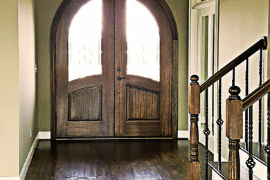 Ejemplo de distribuidor de estilo americano grande con paredes grises, suelo de madera oscura, puerta doble y puerta de madera en tonos medios