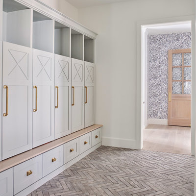 Example of a large country brick floor mudroom design in Phoenix with white walls