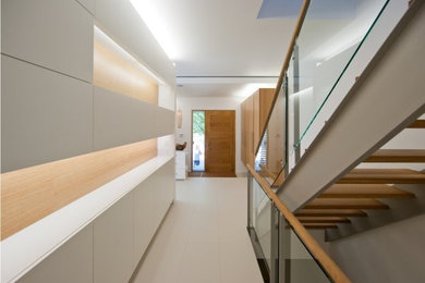 Idéer för en mellanstor modern ingång och ytterdörr, med vita väggar, klinkergolv i porslin, en enkeldörr, mellanmörk trädörr och grått golv