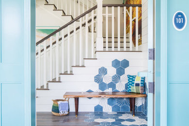 Mid-sized beach style medium tone wood floor and brown floor entryway photo in Orange County with white walls and a blue front door
