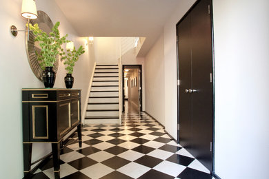 Immagine di un corridoio classico con pareti bianche, una porta a due ante e una porta nera