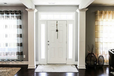 チャールストンにあるお手頃価格の中くらいなトランジショナルスタイルのおしゃれな玄関ドア (グレーの壁、濃色無垢フローリング、白いドア、茶色い床) の写真