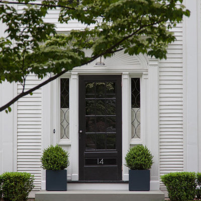 Example of a classic entryway design in Boston with a black front door