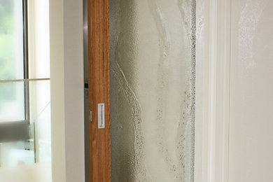 メルボルンにあるラグジュアリーなコンテンポラリースタイルのおしゃれな玄関 (白い壁、黒いドア) の写真