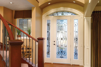 Mittelgroßer Eingang mit beiger Wandfarbe, braunem Holzboden, Einzeltür und Haustür aus Glas in Calgary