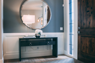 Foyer - large transitional light wood floor foyer idea in Calgary with gray walls and a dark wood front door