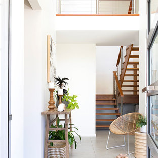 Immagine di un corridoio tropicale con pareti bianche, una porta singola, una porta in vetro e pavimento beige