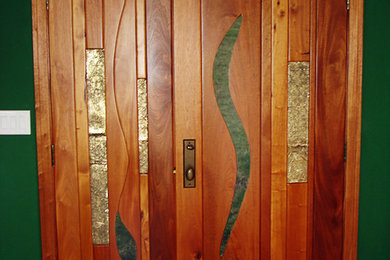 Foto de puerta principal actual de tamaño medio con paredes verdes, suelo de madera en tonos medios, puerta simple y puerta de madera oscura