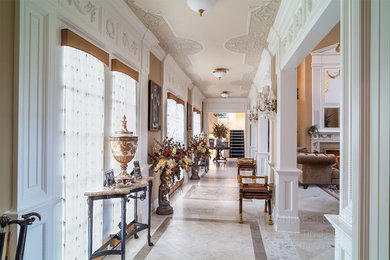 シャーロットにあるラグジュアリーな広いトラディショナルスタイルのおしゃれな玄関ホール (大理石の床、茶色い壁、白いドア) の写真